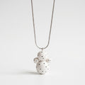 Necklace with a white ceramic pendant on a light gray background