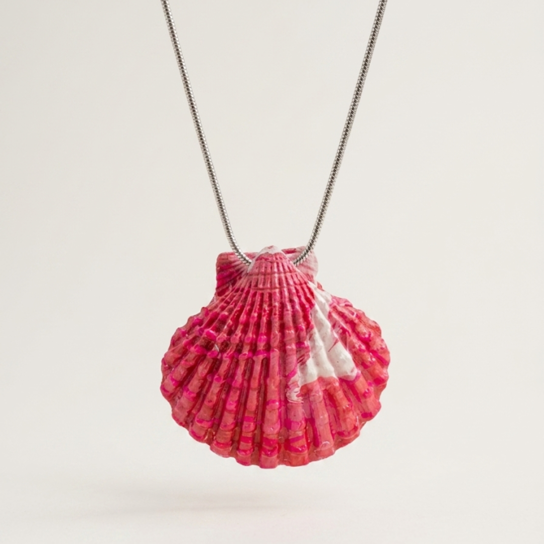 Shell-shaped pendant on a chain against a white background