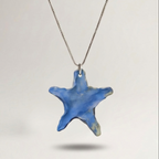 Blue star-shaped pendant on a chain against a light gray background