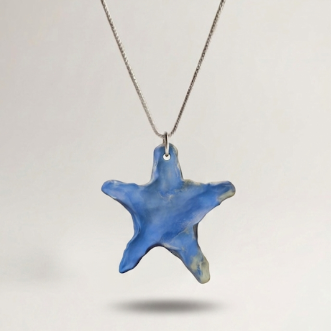 Blue star-shaped pendant on a chain against a light gray background